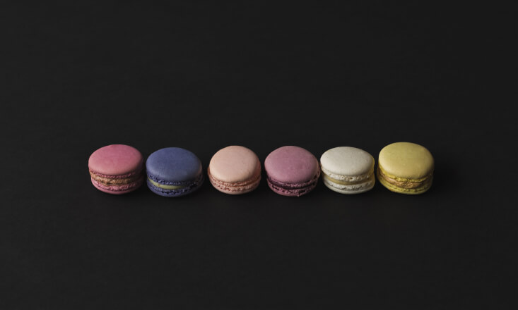 6 macarons laying on a black surface