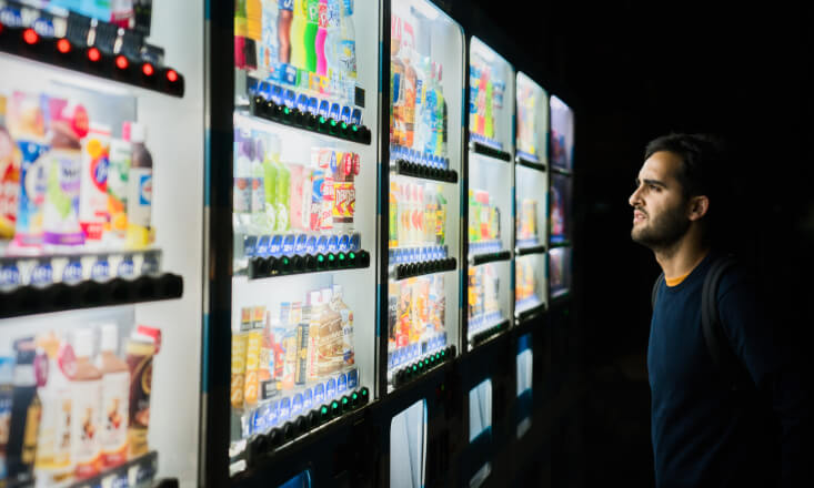 Guy wondering what to choose from a vending machine