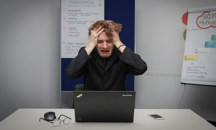 Customer Service Problems: Man pulling his hair from stress, sitting in from of the laptop